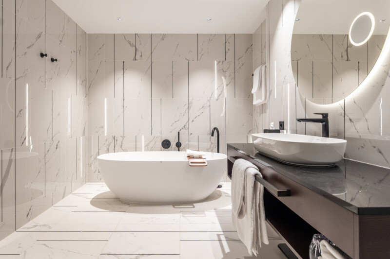 Ein Hotelbad auf höchstem Niveau – harmonisch inszeniert mit durchgängigen Schlüter-Systemlösungen für Abdichtung, Beheizung, Profiltechnik und Licht.