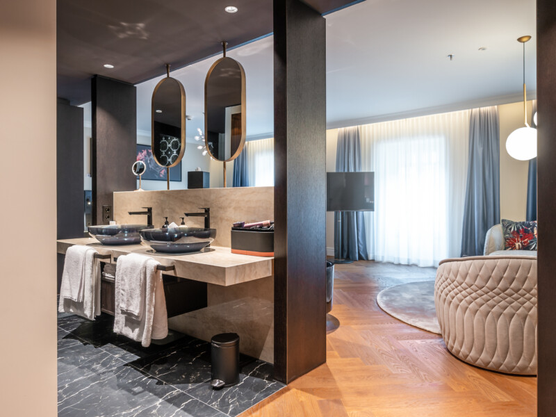 Die Spa-Suite verbindet Wohnen und Wellness in einem offenen Raumkonzept – mit freistehender Badewanne, angrenzender Sauna und warmen Naturmaterialien.