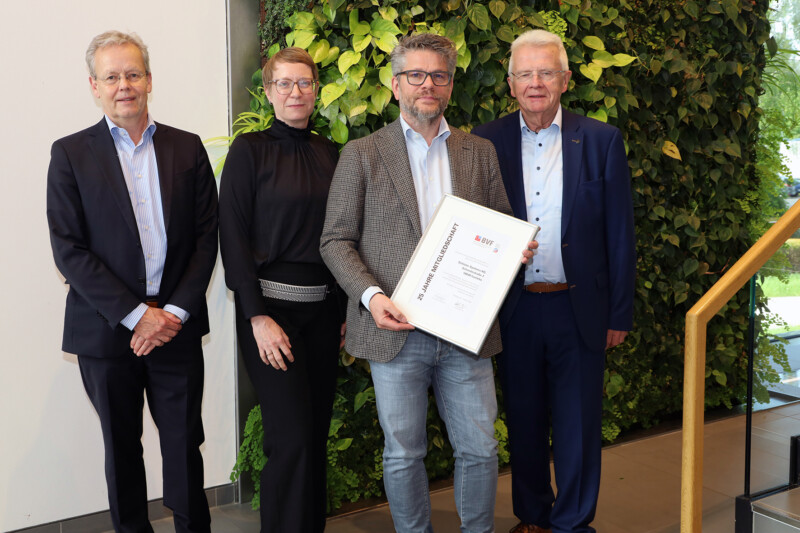 Ulrich Stahl gratuliert Marc Schlüter zur 25-jährigen Mitgliedschaft von Schlüter-Systems im BVF und überreicht die Jubiläumsurkunde